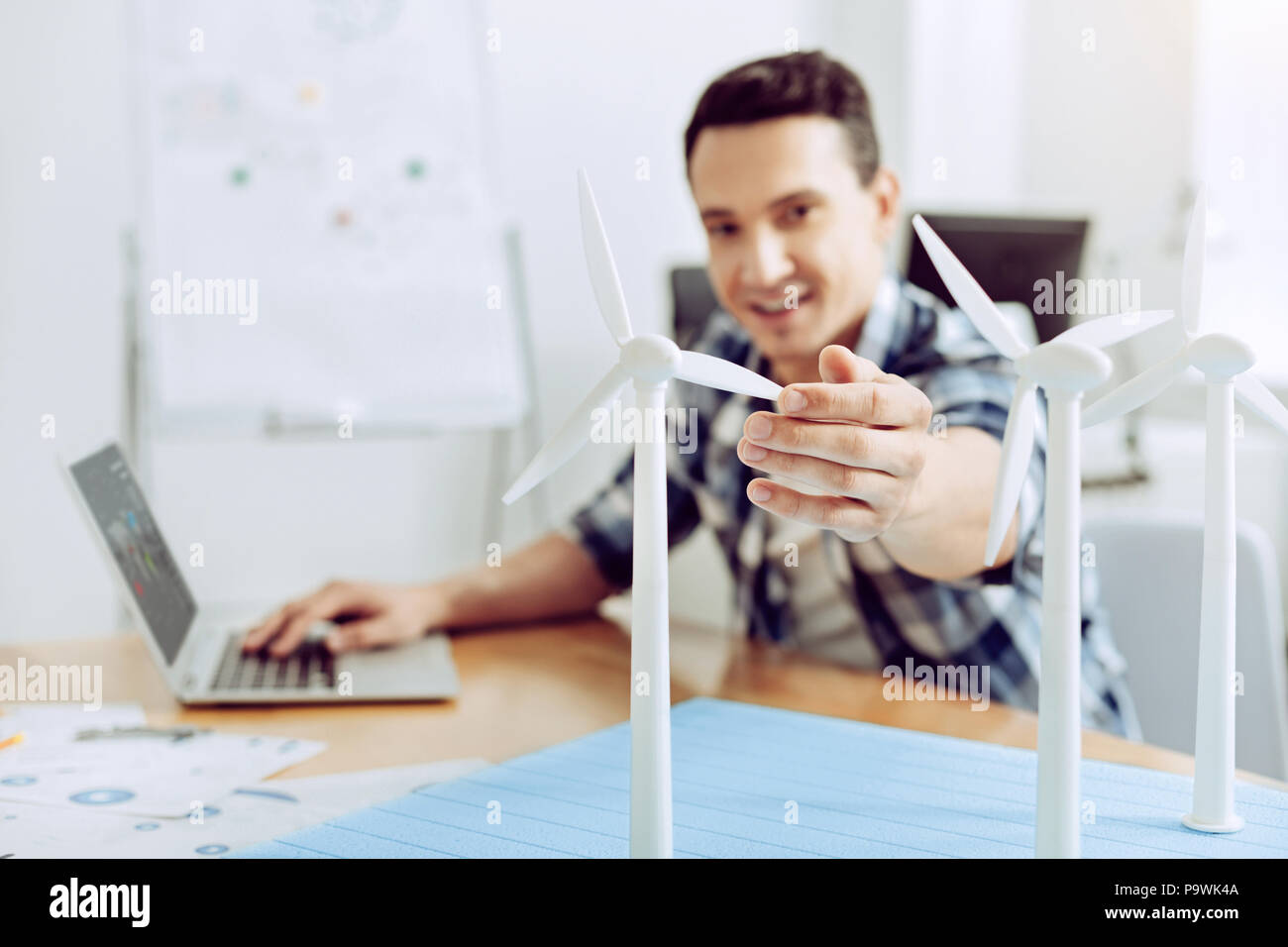 Successful engineer. Qualified successful cheerful engineer looking glad while working in his office Stock Photo