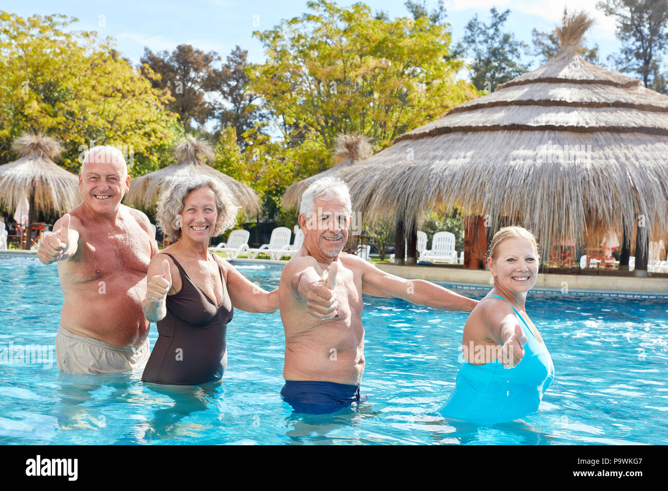 Senior Pool Fun Cheerful group of seniors has fun in the pool and keeps their fingers ...