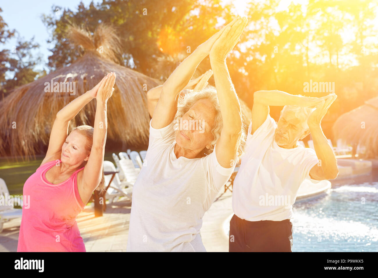 Senior group makes yoga class on vacation for relaxation Stock Photo