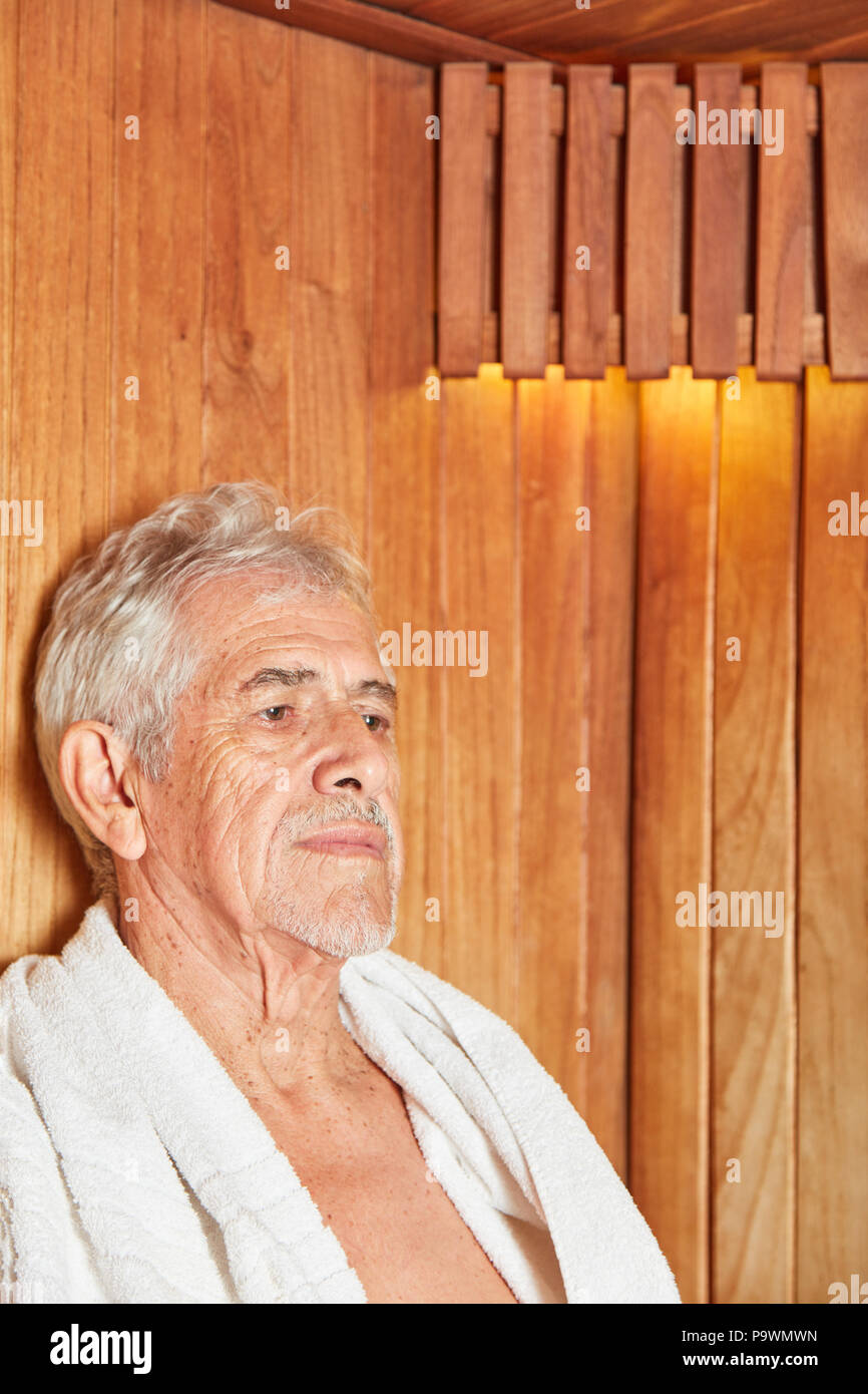 Senior man relaxes in the sauna in the spa and looks serious and thoughtful Stock Photo