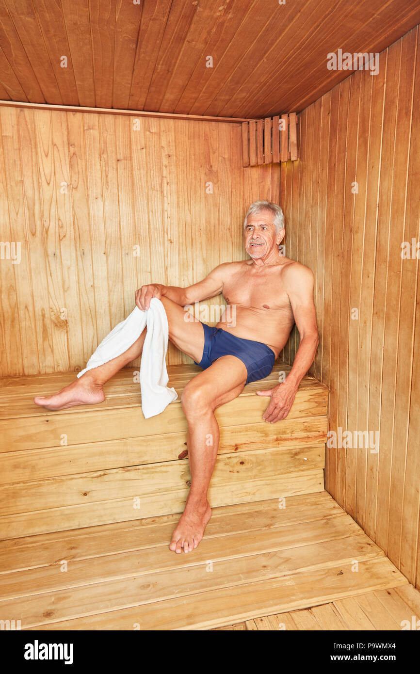 Senior man enjoys the heat in the sauna for health and relaxation Stock Photo