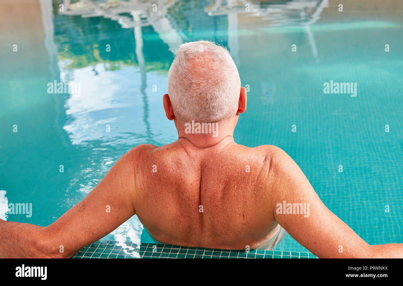 Senior man relaxes in swimming pool at Spa Wellness Hotel Stock Photo