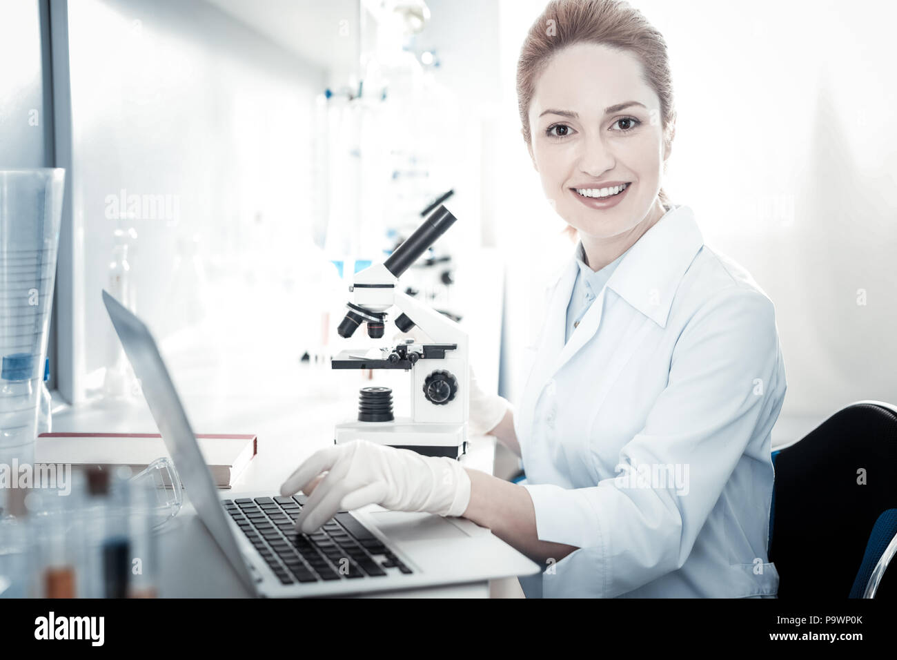 Happy female scientist working at the laptop Stock Photo