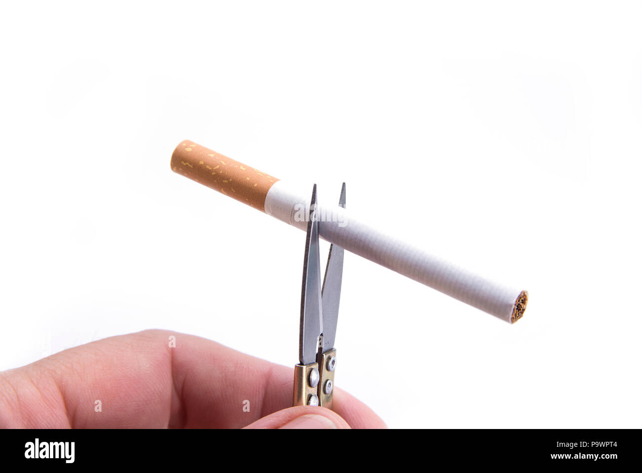 Detail of cigarette cut with the hand scissors. Stop smoking concept Stock  Photo