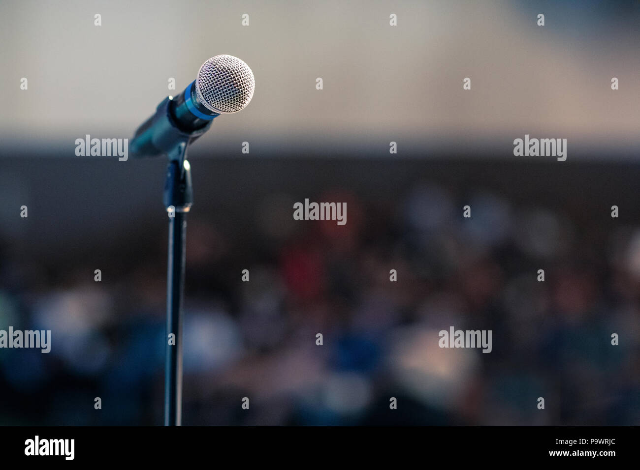 A microphone standing in front of the auditorium on a stand, waiting ...