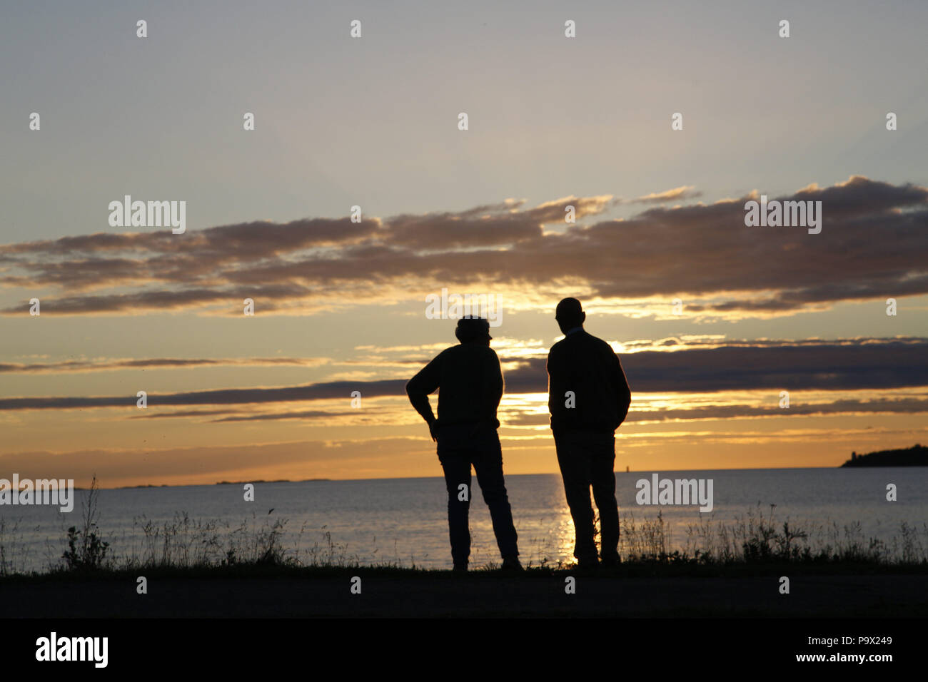 Two silhouetted people at sunset Stock Photo