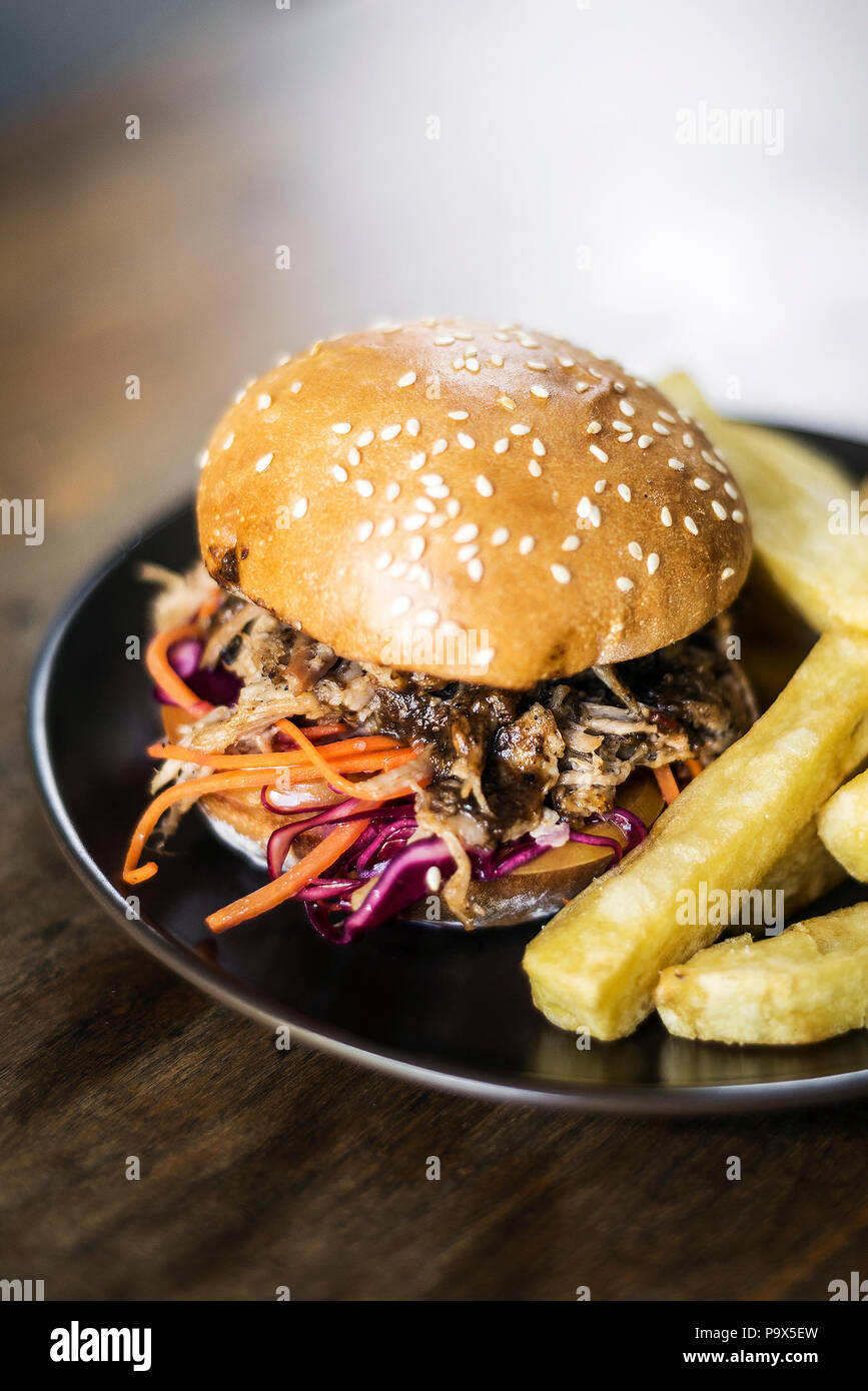 pulled pork and coleslaw salad burger sandwich with french fries snack meal Stock Photo