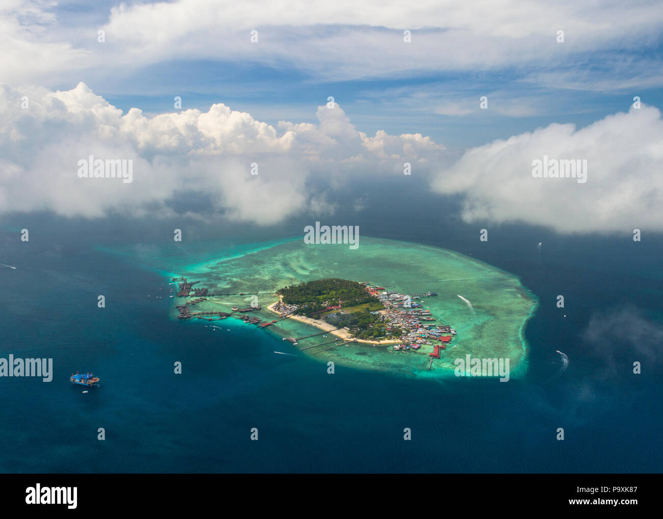 A distant drone photo of Mabul Island in Sabah, Malaysia (Borneo), with blue sky and clouds above. Stock Photo