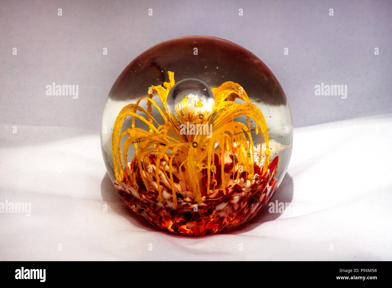 Glass Ball With Yellow And Red Decorative Elements In It Stock