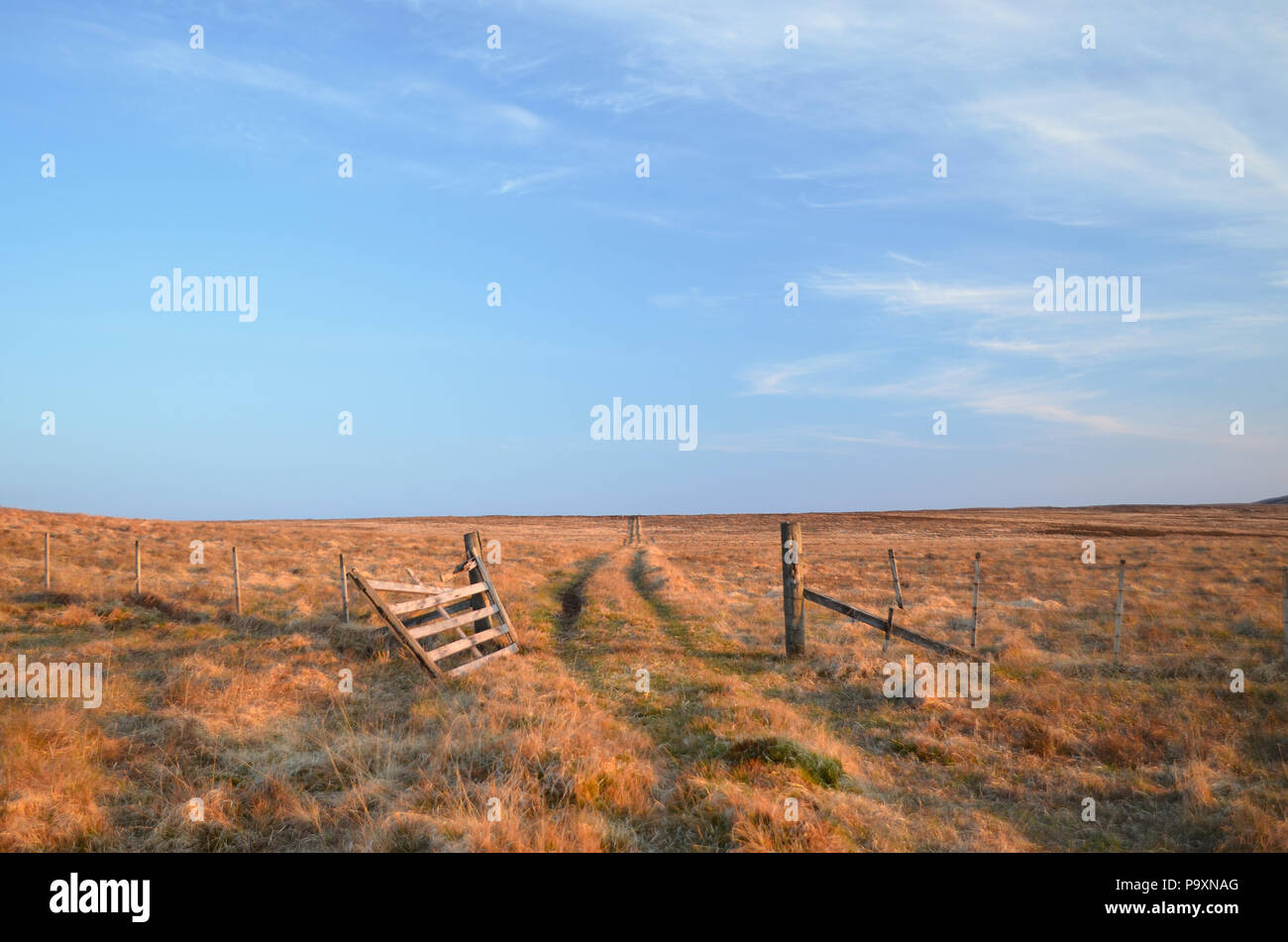 A broken wooden gateway and rough track on a remote area of moorland in the Scottish Highlands Stock Photo
