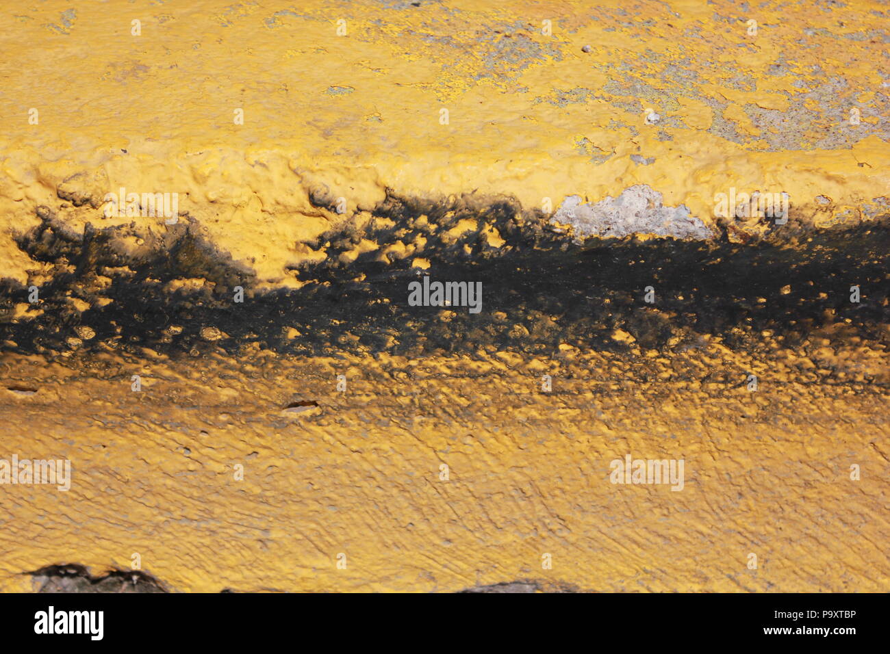 Safety yellow painted street curb on a sunny summer day. Stock Photo