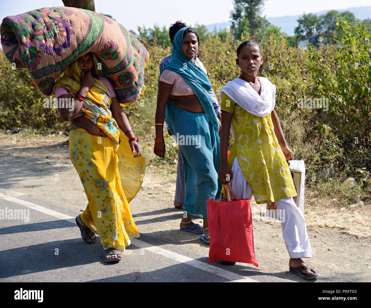 Indian local women wives of farmers, walk home after trading at a local