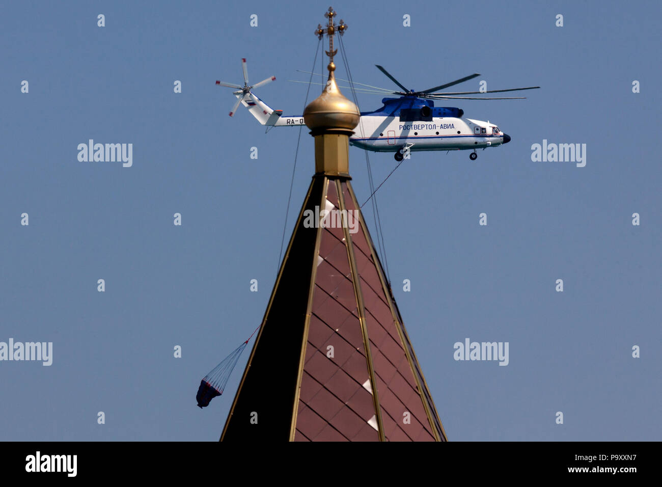 The Mil Mi-26T heavy helicopter flies behind the Russian orthodox church during the Hydro Airshow-2012 in Gelendzhik, Russia. Stock Photo
