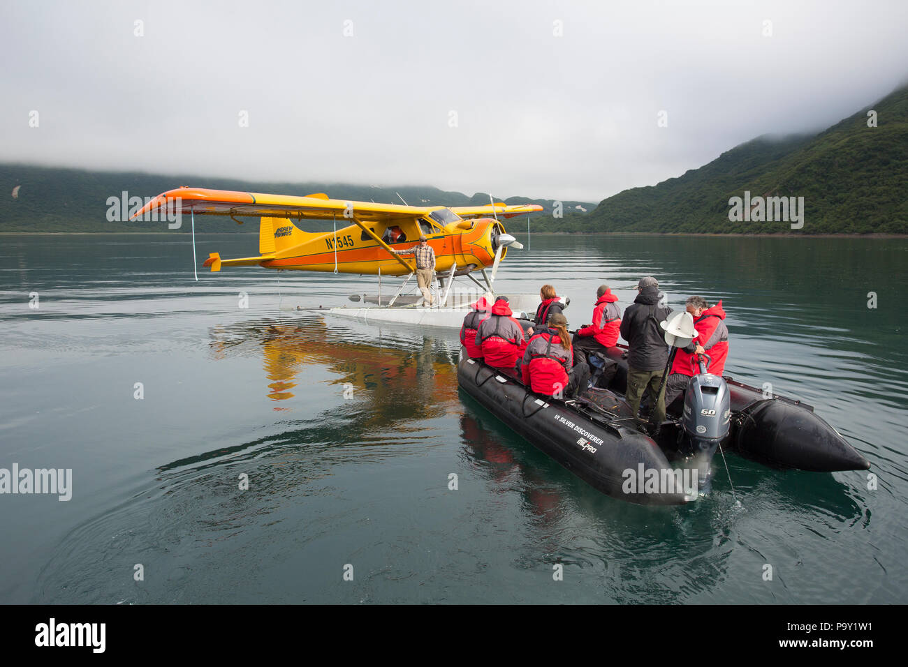 Cruise Ship Tourists transfer from zodiac into float plane, Alaskan Wilderness Stock Photo
