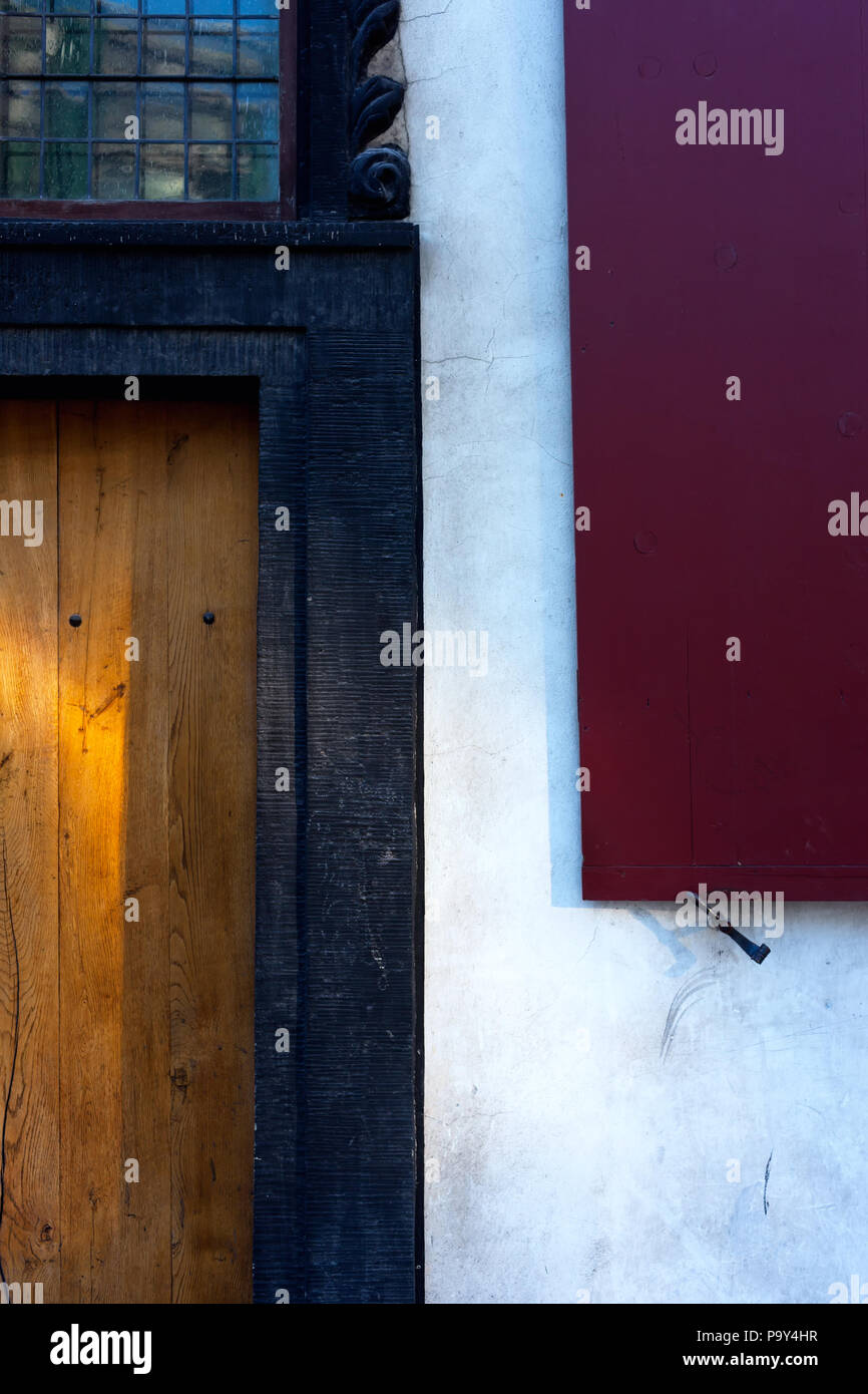 Red Shutters And Yellow Wooden Door With Glare Of The Sun On The
