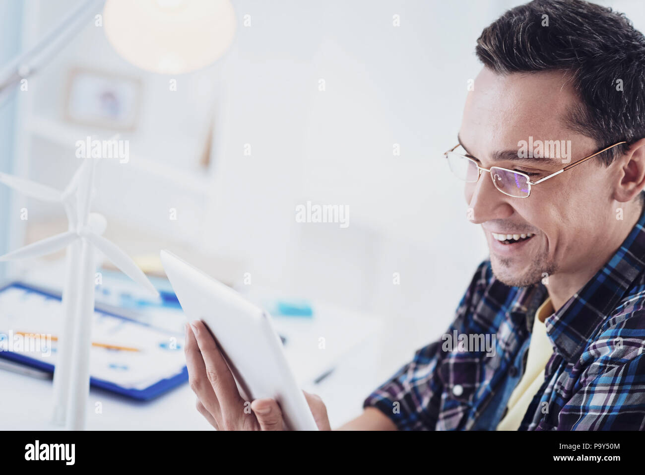 Close up of delighted male that staring at his tablet Stock Photo