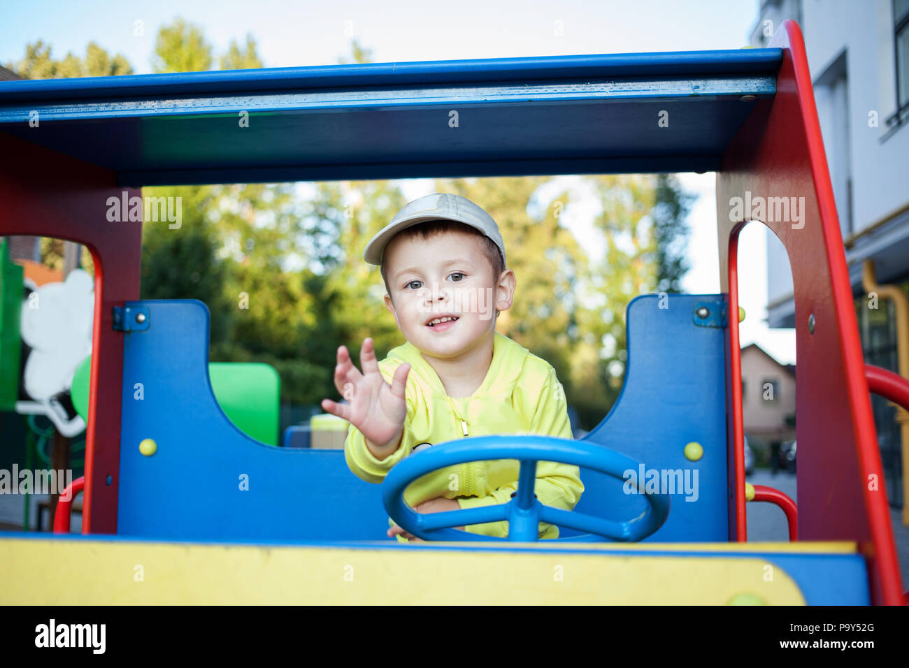 Cute little boy is playing in a big toy wooden car Stock Photo - Alamy
