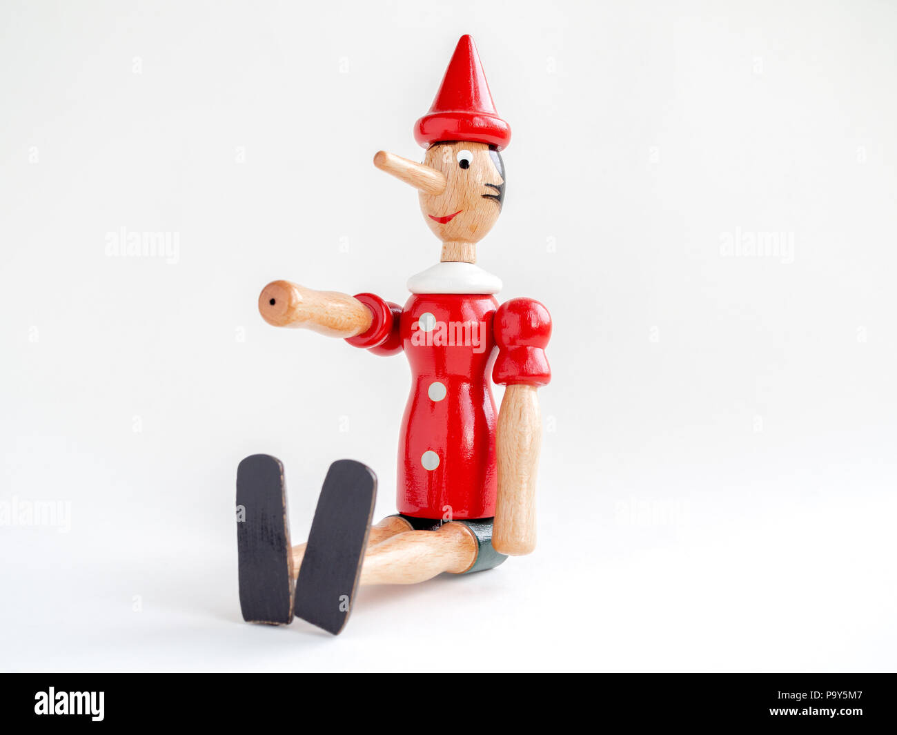 Wooden Pinocchio doll sitting and hand up isolated on white background ...