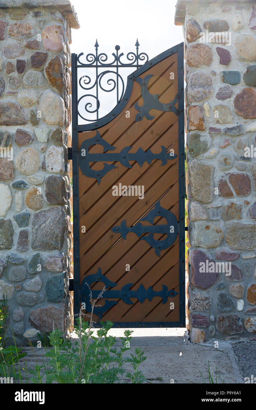 Classical design black wrought iron gates in private yard rural setting. Stock Photo