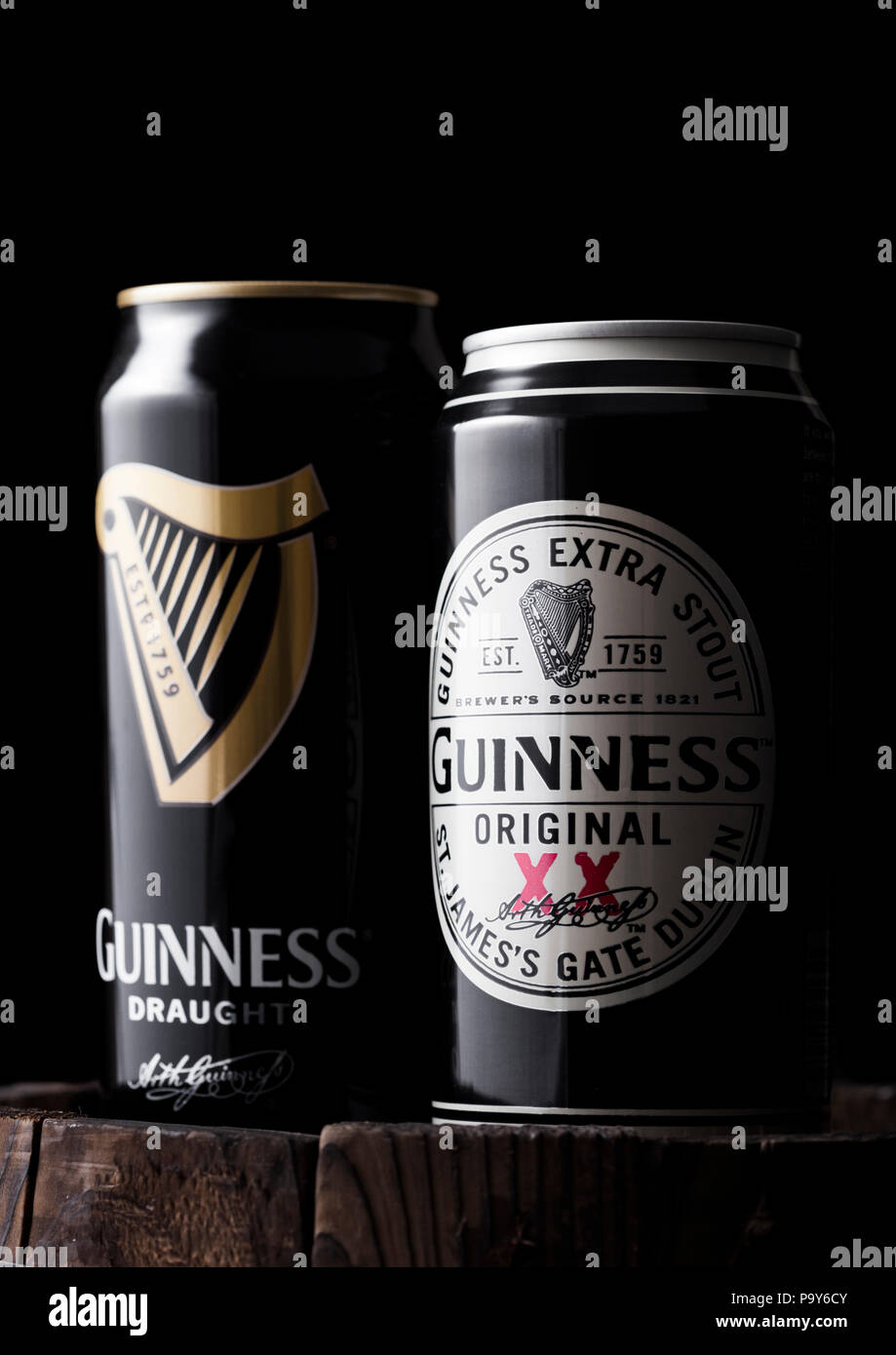LONDON, UK - APRIL 27, 2018: Aluminium can of Guinness original and draught stout beer on top of old wooden barrel. Guinness beer has been produced si Stock Photo