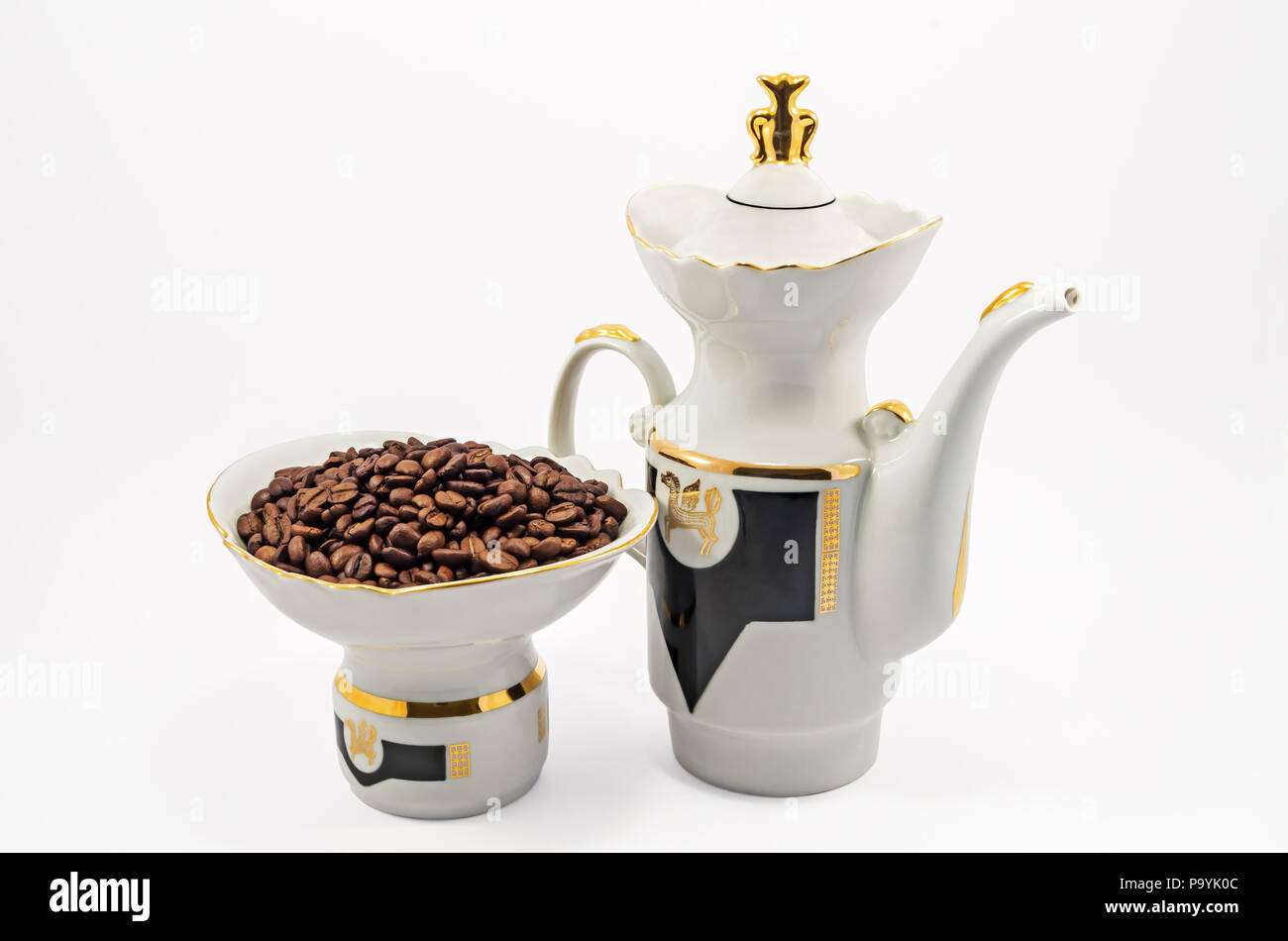 Oldfashioned porcelain coffee pot and a bowl of coffee beans isolated