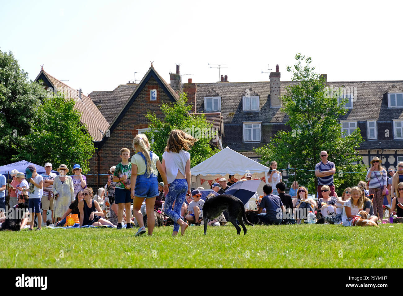 East Preston, West Sussex, UK. Fun dog show held on village green. Young girls showing their pet three legged dog. Stock Photo