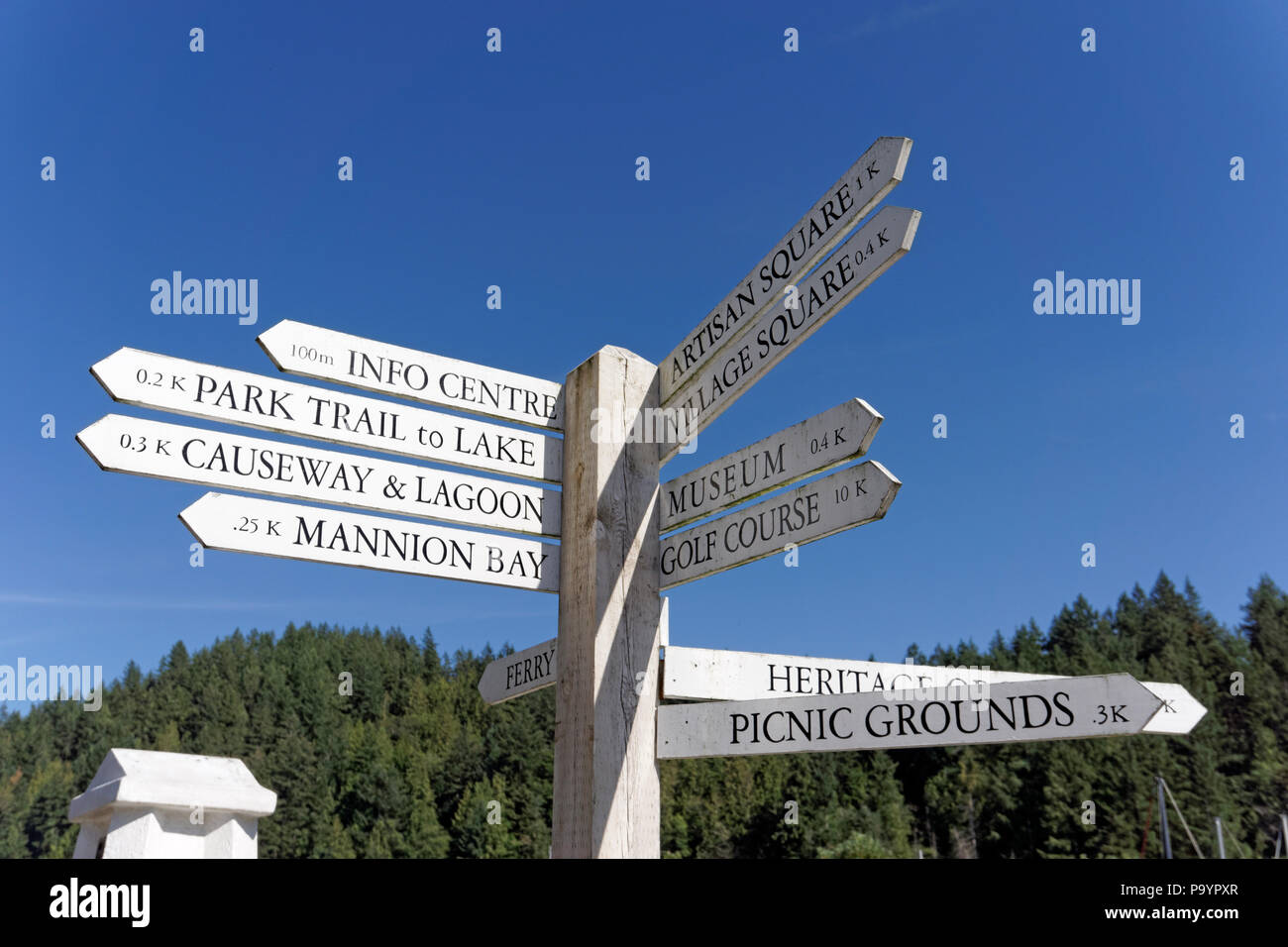 Wooden signpost showing direction and distance in kilometers to tourist attractions on Bowen Island near Vancouver, British Columbia, Canada Stock Photo