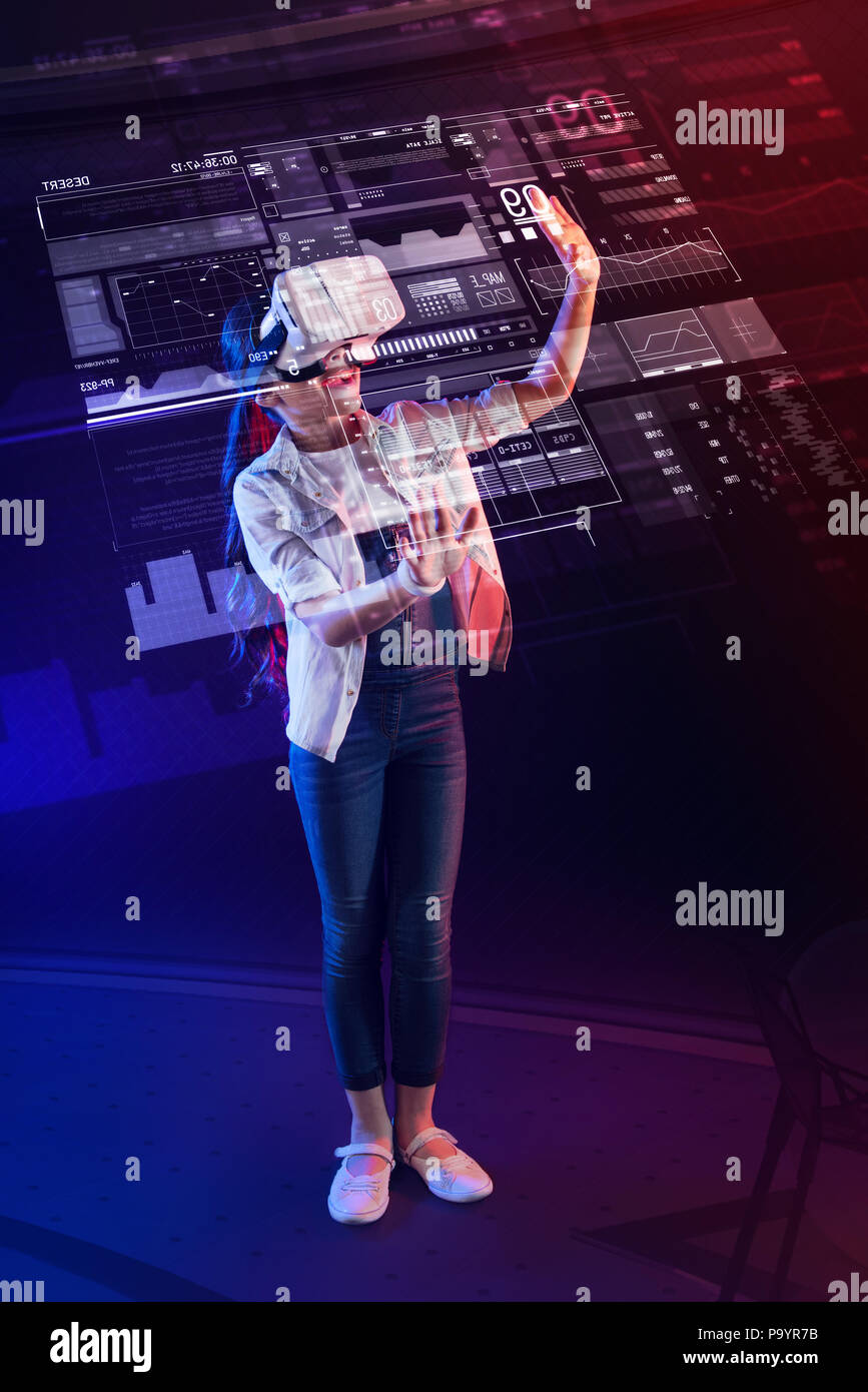 Clever girl creating a detailed projection and wearing virtual reality glasses Stock Photo