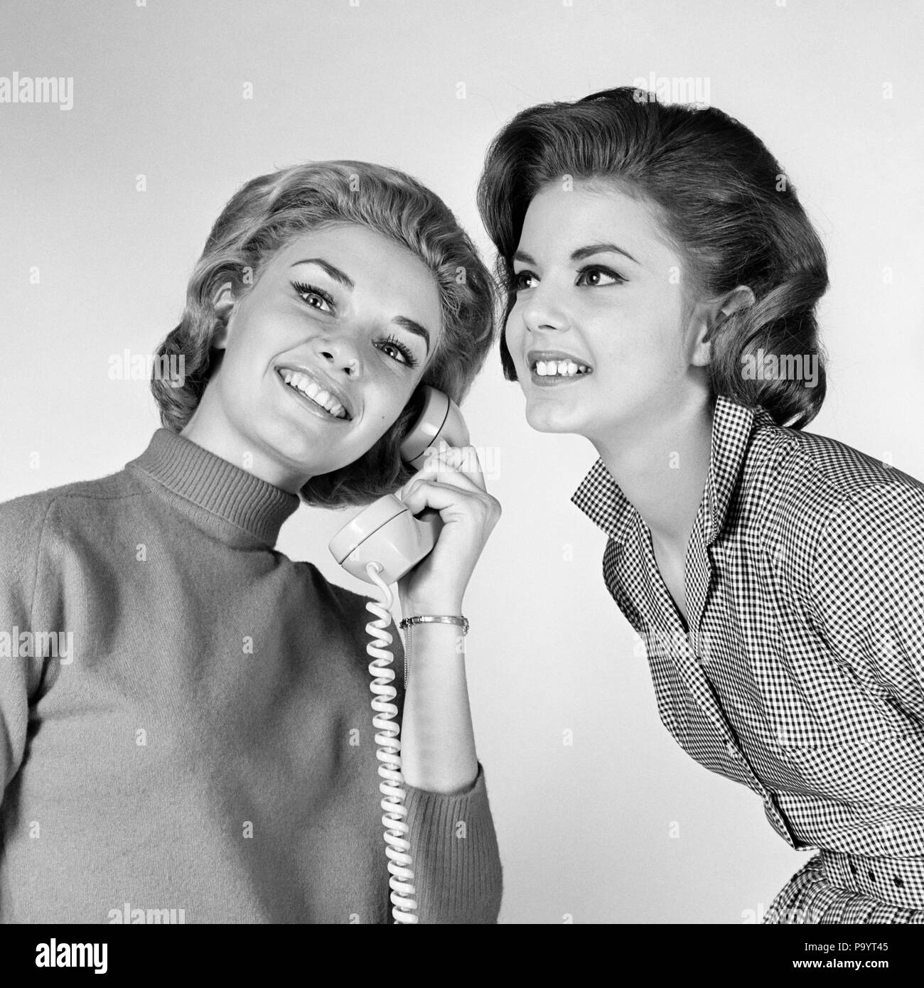 1960s TWO WOMEN LISTENING TO SINGLE TELEPHONE RECEIVER - bt00162 CAM001 HARS NETWORKING EXCITEMENT CAM001 PHONES SIBLING CONNECTION TELEPHONES GIRLFRIENDS RECEIVER STYLISH OVERHEAR COMMUNICATIONS EAVESDROPPING MID-ADULT MID-ADULT WOMAN TELECOMMUNICATIONS TOGETHERNESS YOUNG ADULT WOMAN BLACK AND WHITE CAUCASIAN ETHNICITY OLD FASHIONED Stock Photo