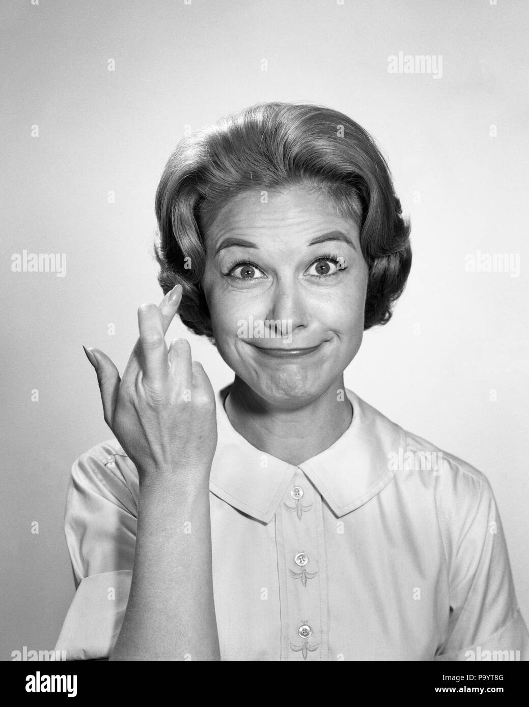 1960s Woman Funny Facial Expression With Fingers Crossed For Luck