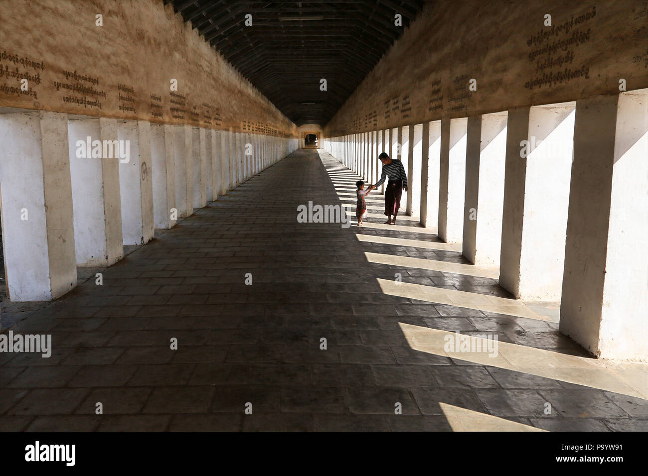 Father and son in covered walkway to Shwezigon pagoda, Nyaung-U Stock Photo