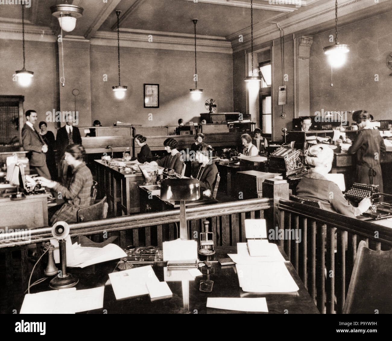 1910s 1920s BUSINESS OFFICE WITH WOMEN SITTING AT DESKS IN BULLPEN AREA -  o2383 SPL001 HARS COPY SPACE HALF-LENGTH LADIES PERSONS MALES PROFESSION  B&W DESKS MEN AND WOMEN DECOR OCCUPATION TYPING AND