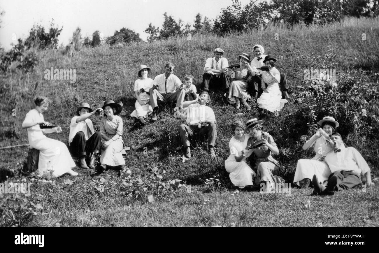 1890s 1900s TURN OF THE 20TH CENTURY GROUP OF COUPLES MEN & WOMEN DRINKING MANY BOTTLES OF ADULT BEVERAGES SITTING ON HILLSIDE  - o3624 LEF001 HARS YOUNG ADULT BALANCE COMIC TEAMWORK RELAXING PLEASED JOY LIFESTYLE CELEBRATION FEMALES RURAL GROWNUP HORIZONTAL COPY SPACE FRIENDSHIP FULL-LENGTH PERSONS RISK SUNNY B&W MEN AND WOMEN FREEDOM TEMPTATION ALCOHOLIC HUMOROUS HAPPINESS CHEERFUL ADVENTURE BEVERAGE LEISURE TURN OF THE 20TH CENTURY AND RECREATION COMICAL SMILES COMEDY ESCAPE JOYFUL LAUGHTER MEMBERS STYLISH SPIRITS DAYLIGHT HILLSIDE MEMBER RELAXATION TOGETHERNESS WINEGLASS WINES Stock Photo