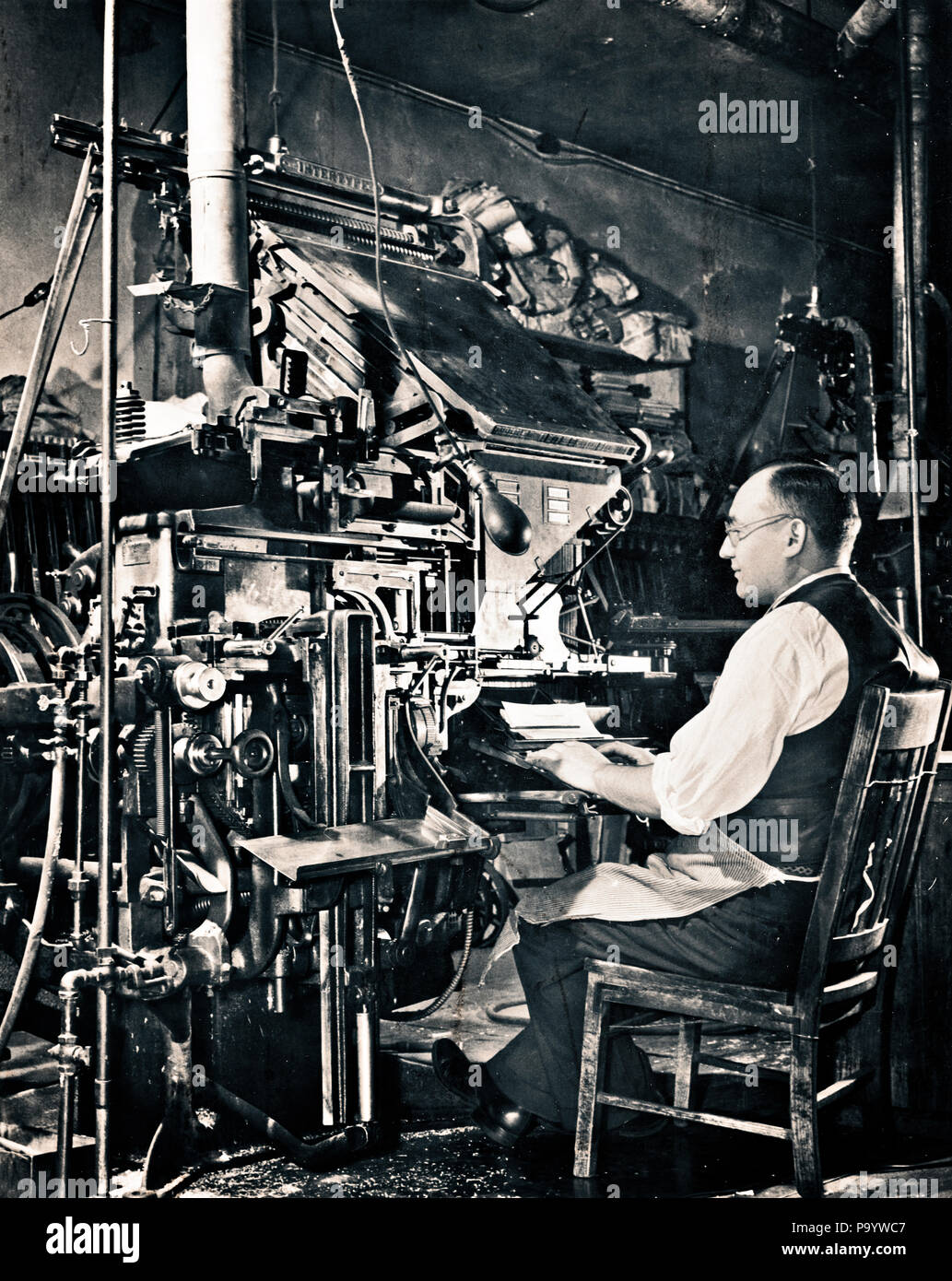 1930s ANONYMOUS MAN SEATED AT COMPOSING KEYBOARD OF LINOTYPE HOT METAL TYPESETTING MACHINE  - q43089 CPC001 HARS MALES MECHANICAL MIDDLE-AGED B&W MIDDLE-AGED MAN SKILL OCCUPATION SKILLS LABOR EMPLOYMENT OCCUPATIONS TYPE ANONYMOUS COMPOSE EMPLOYEE TYPESETTING LETTERPRESS TYPESETTER BLACK AND WHITE CAUCASIAN ETHNICITY LABORING OLD FASHIONED PUBLISHING Stock Photo