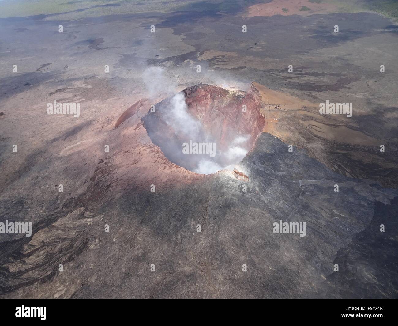 Aerial photo of Halemaumau and part of the Kilauea caldera floor at the summit as the volcano continues to erupt July 17, 2018 in Hawaii. In the lower third of the image, you can see the buildings that housed the USGS Hawaiian Volcano Observatory and Hawaii Volcanoes National Park Jaggar Museum. Stock Photo