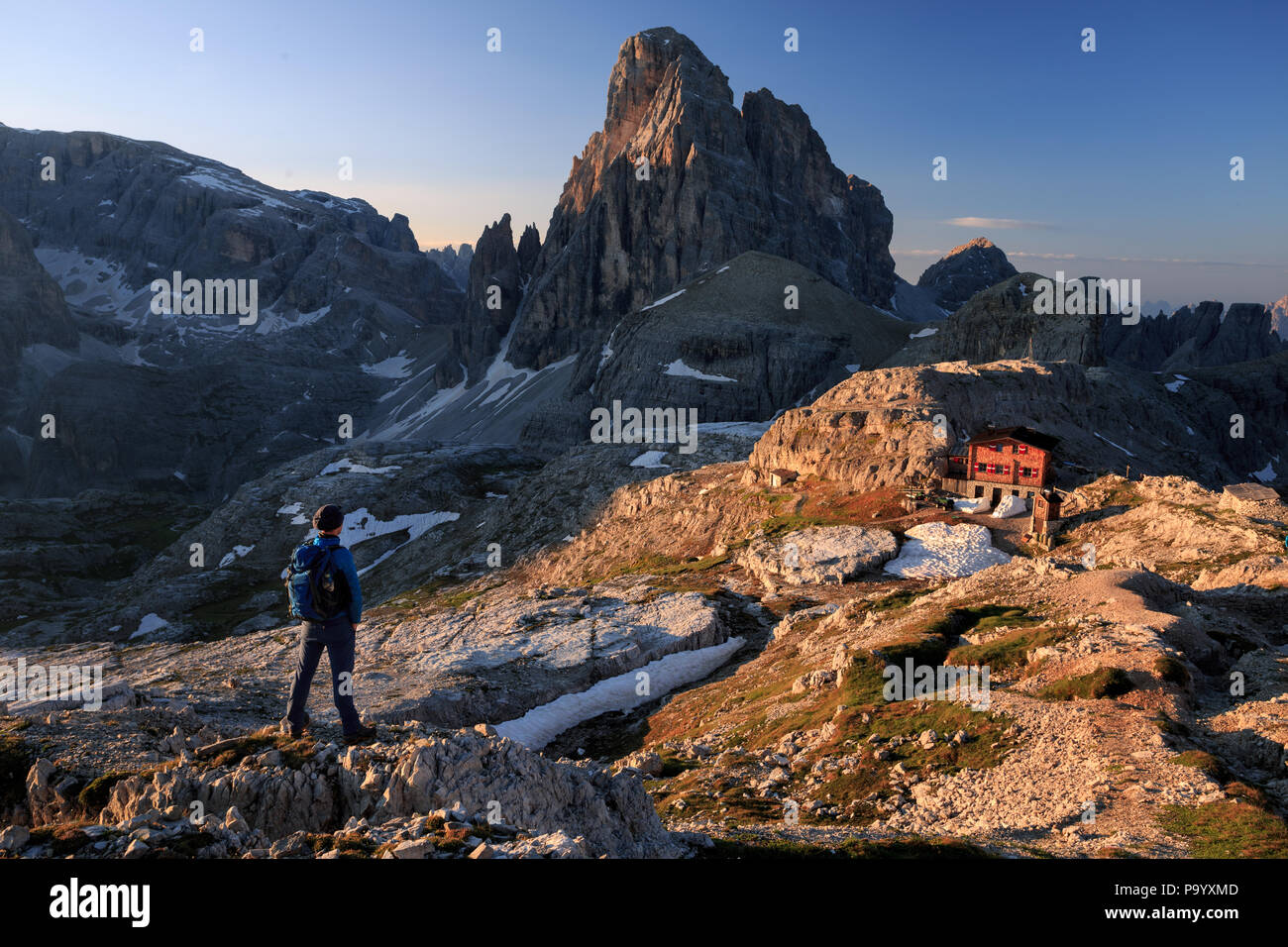Hiker enjoying the morning view of croda dei toi and rifugio poan di cengia Stock Photo