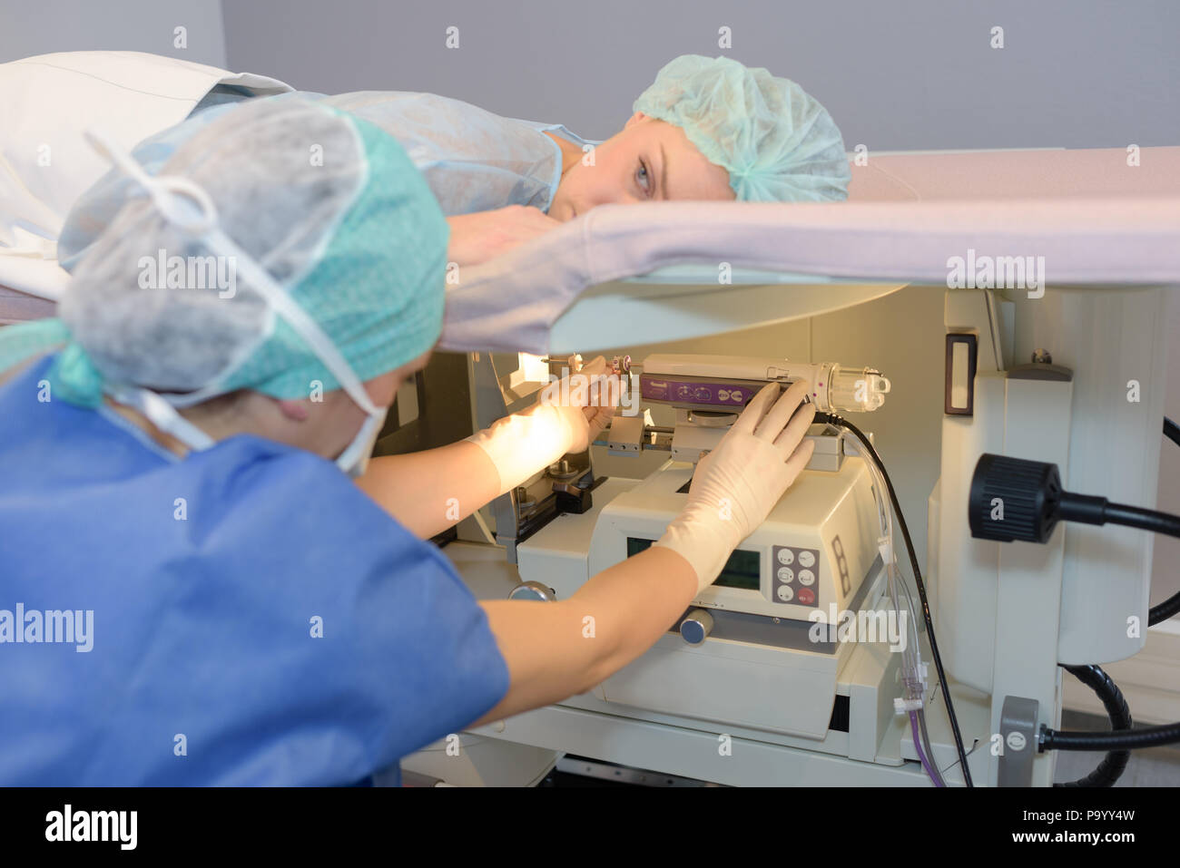 Woman layed on hospital stretcher above diagnostic machine Stock Photo ...
