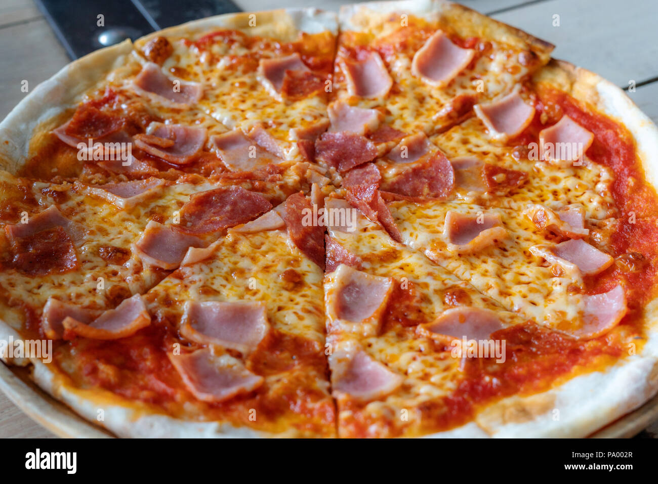 Close-up pizza ham cheese with tomato sources on wooden tray Stock Photo