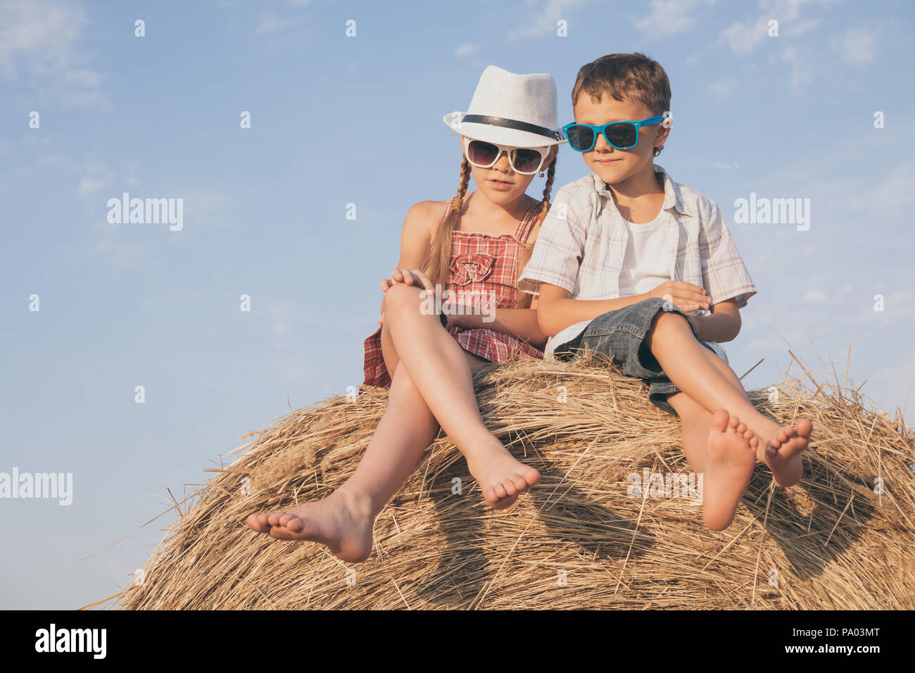 Happy children playing in the park at the day time. Kids having fun outdoors. Concept of summer vacation and friendly family. Stock Photo