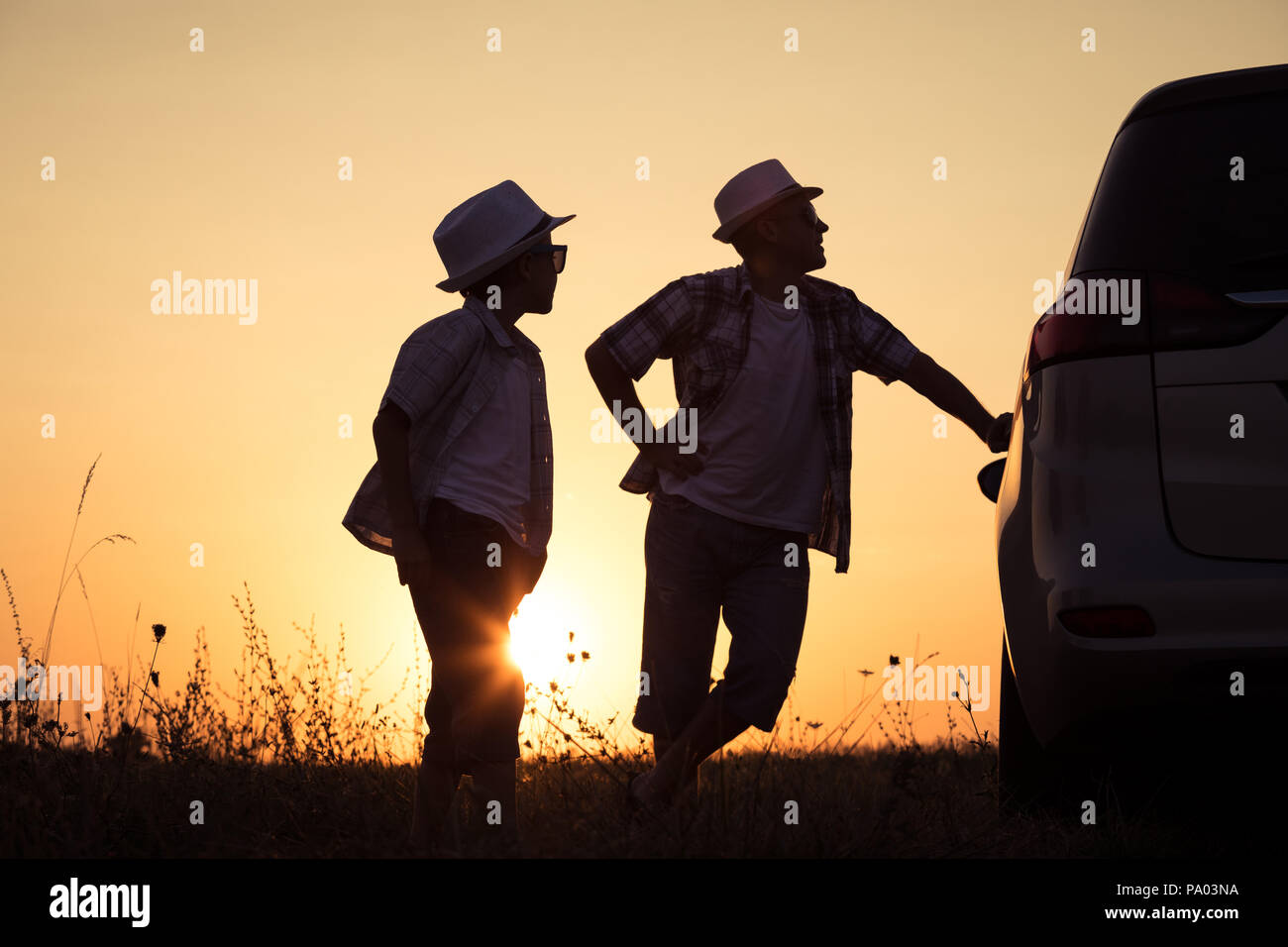 Father and son playing in the park at the sunset time. People having fun outdoors. Concept of summer vacation and friendly family. Stock Photo