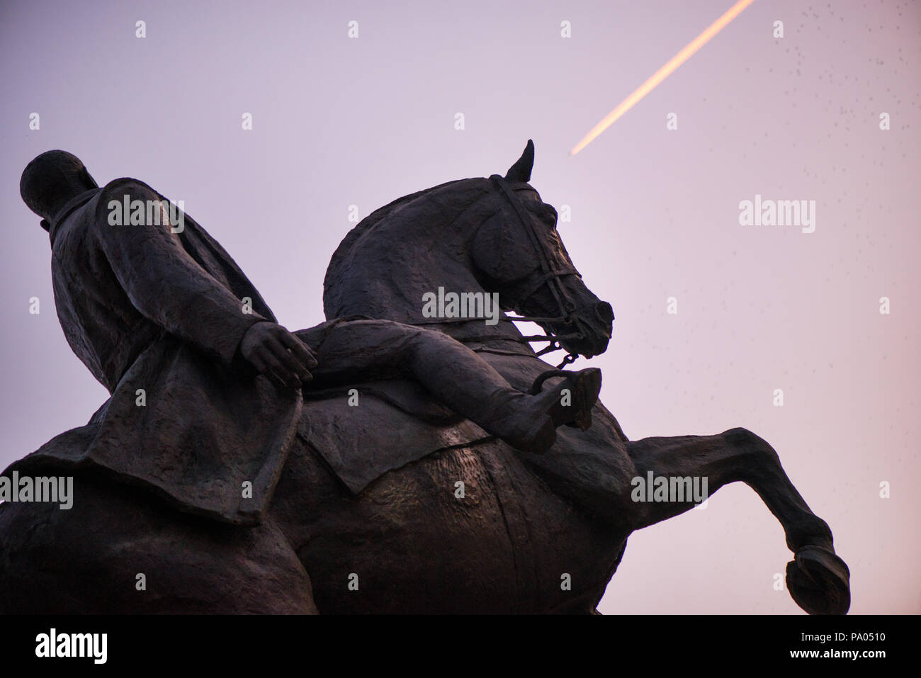 Statue of knight and horse riding towards victory. New moon, birds and ...