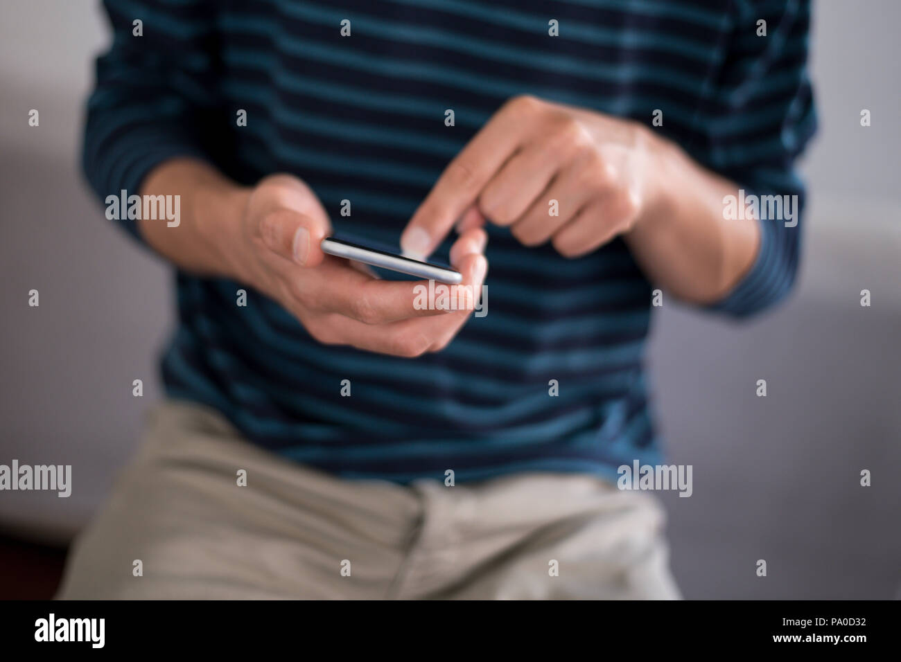 Young man using a touchscreen smartphone - Hands close-up - Using technology Stock Photo