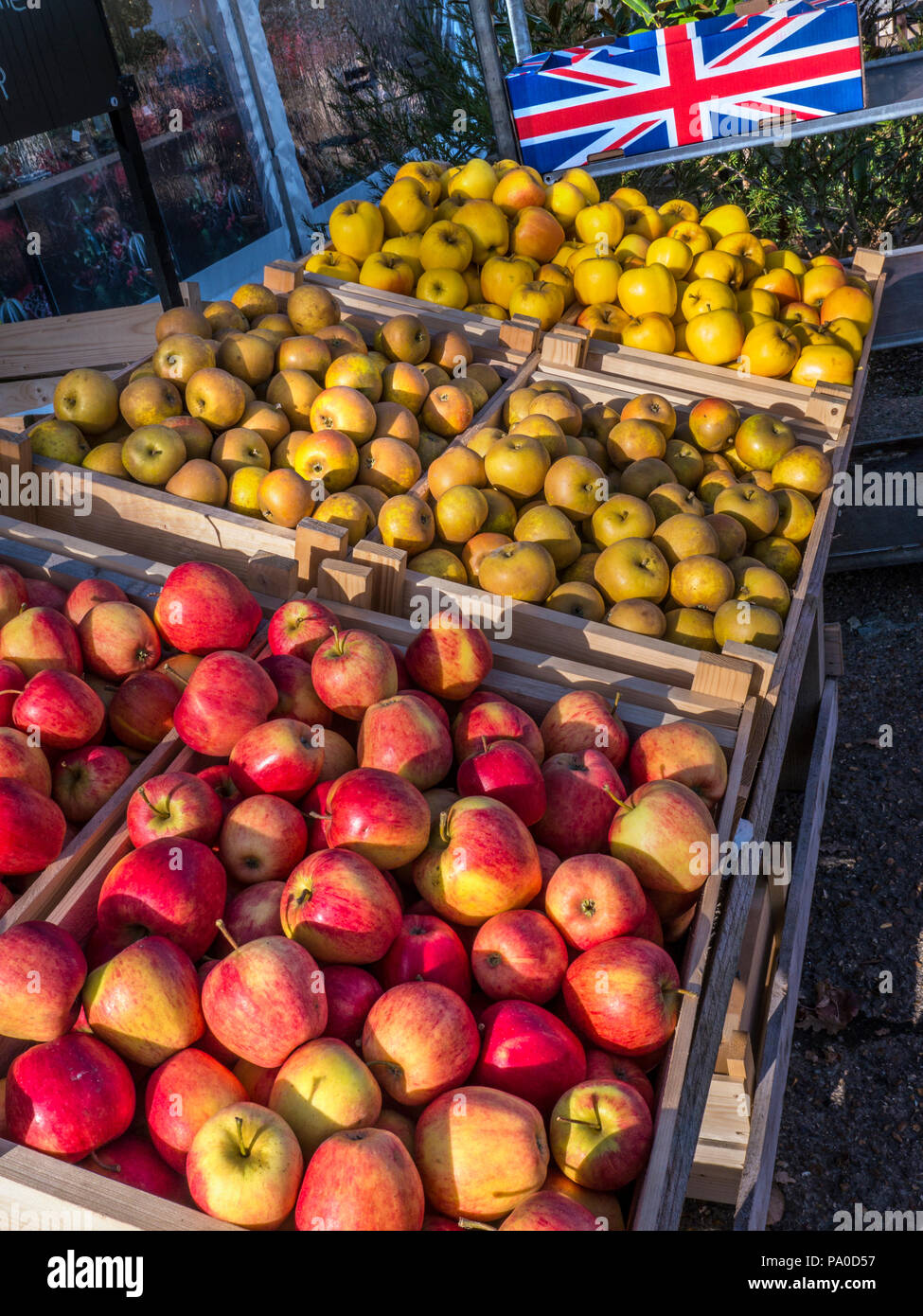 English Apples Union Flag Produce Farmers Market stall Pinova / Russet / Opal apples illuminated late autumn sunshine with Union Jack on apple crate Stock Photo
