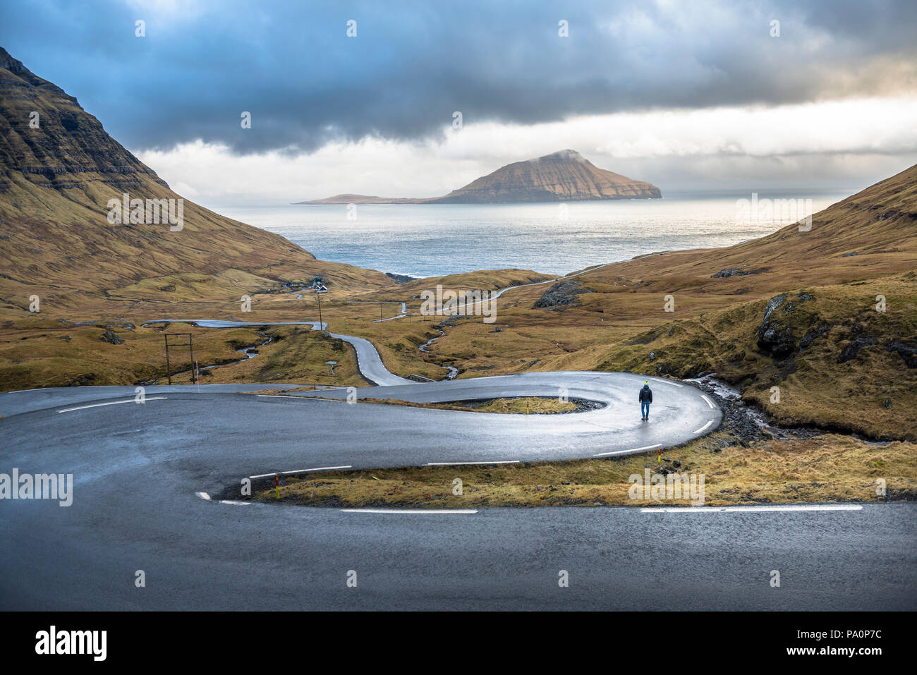 Man walking on winding road on seashore hi-res stock photography and ...
