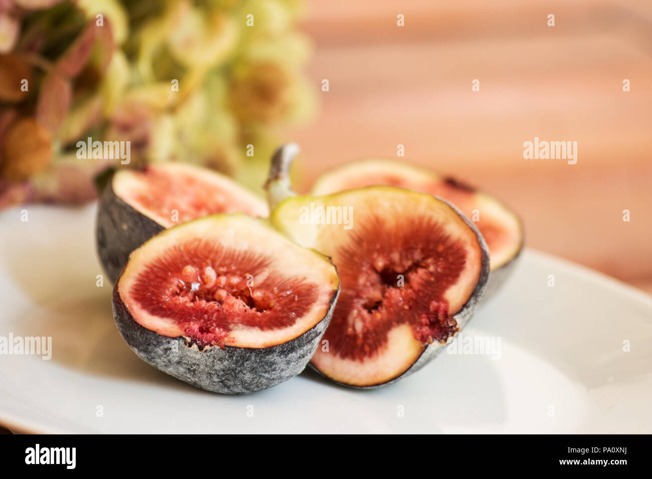 Figs in a plate on wooden table Stock Photo