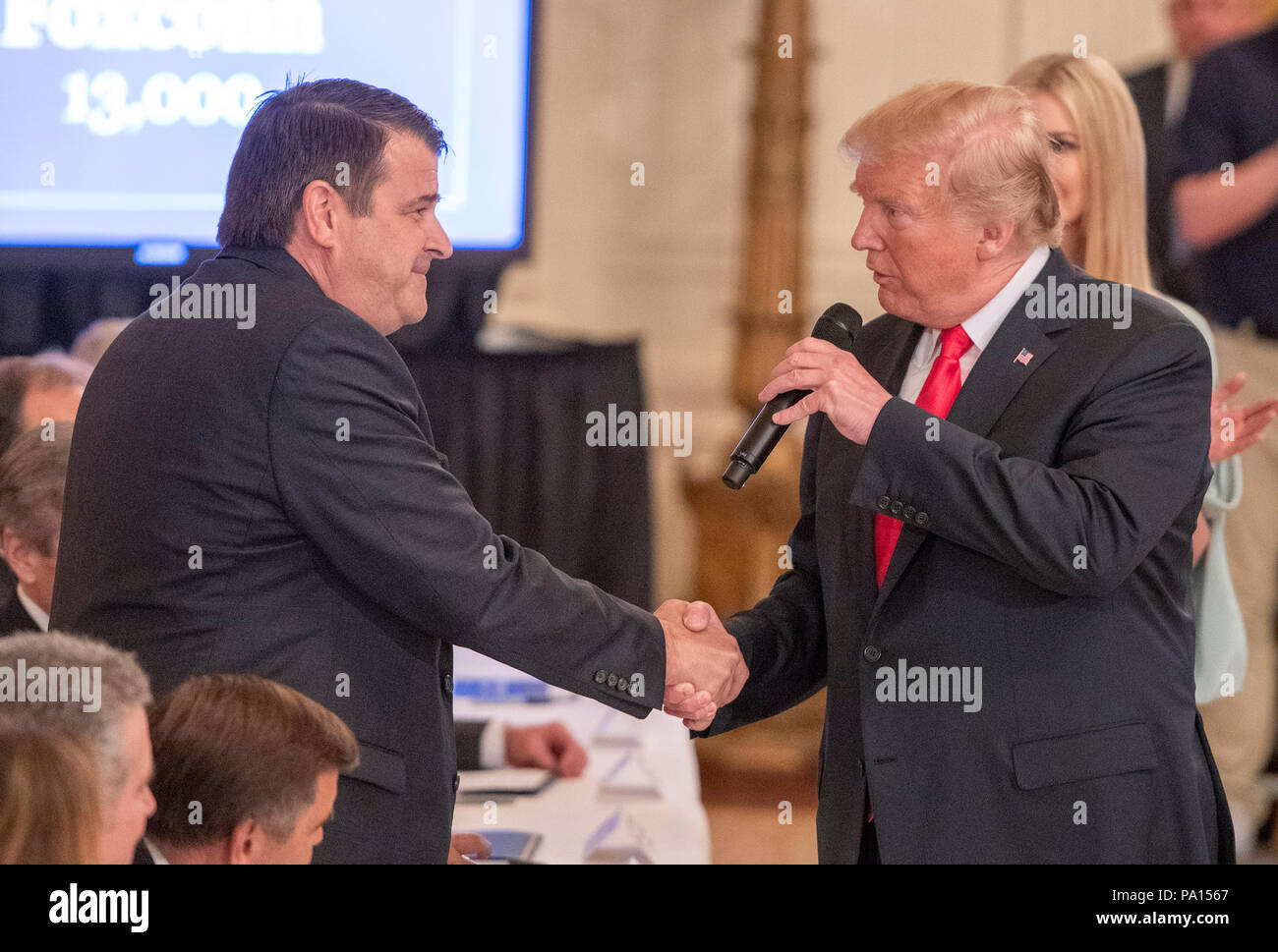 Washington DC, USA. 19th July, 2018. United States President Donald J. Trump, right, shakes hands with retired US Navy Captain Chris Murdoch, special advisor, Foxconn, left, who agreed to target 13,000 jobs after the President signed an Executive Order establishing the National Council for the American Worker, which the Trump Administration calls 'an Interagency Council of Administration officials who will focus on crafting solutions to our country's urgent workforce issues' in the East Room of the White House in Washington, DC on Thursday, July 19, 2018. Credit: MediaPunch Inc/Alamy Live News Stock Photo