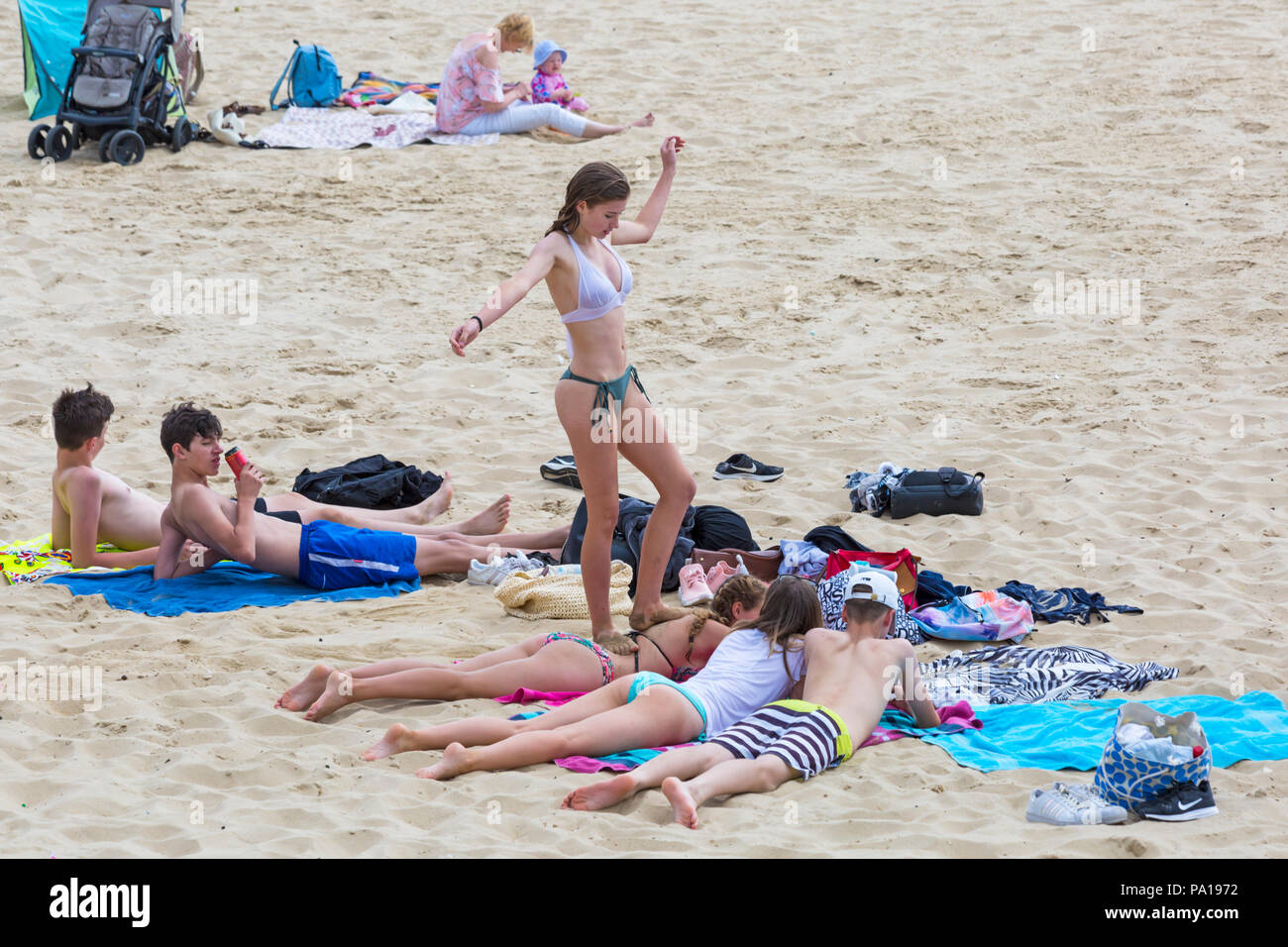 Bournemouth, Dorset, UK. 20th July 2018. UK weather: hot and humid with hazy sunshine at Bournemouth, as sunseekers head to the seaside at Bournemouth beaches to enjoy the fine weather. Group of friends sunbathing and having fun on the beach. Credit: Carolyn Jenkins/Alamy Live News Stock Photo