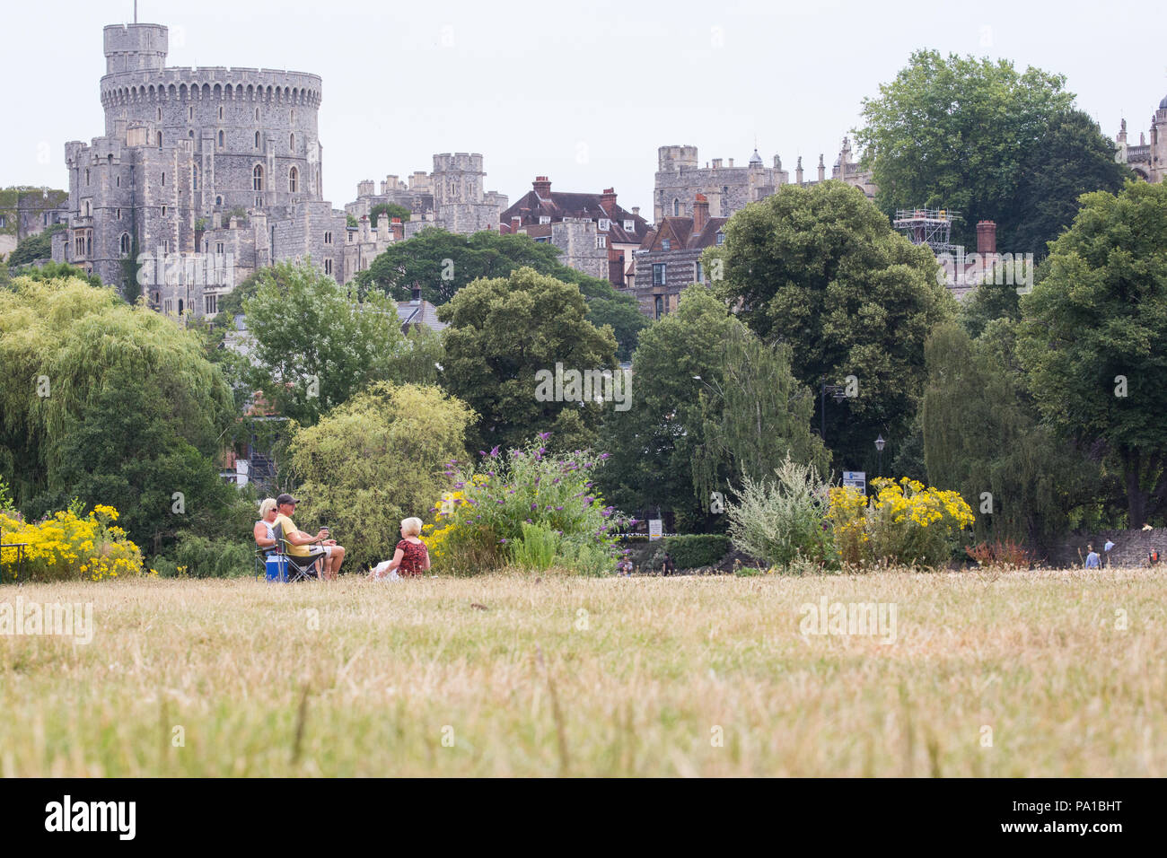 Windsor, UK. 20th July, 2018. Yellowed grass at the Brocas in Eton with Windsor Castle behind following the UK's longest heatwave for more than forty years. The grass around Windsor Castle was a lush green at the time of the wedding of the Duke and Duchess of Sussex in May. Credit: Mark Kerrison/Alamy Live News Stock Photo