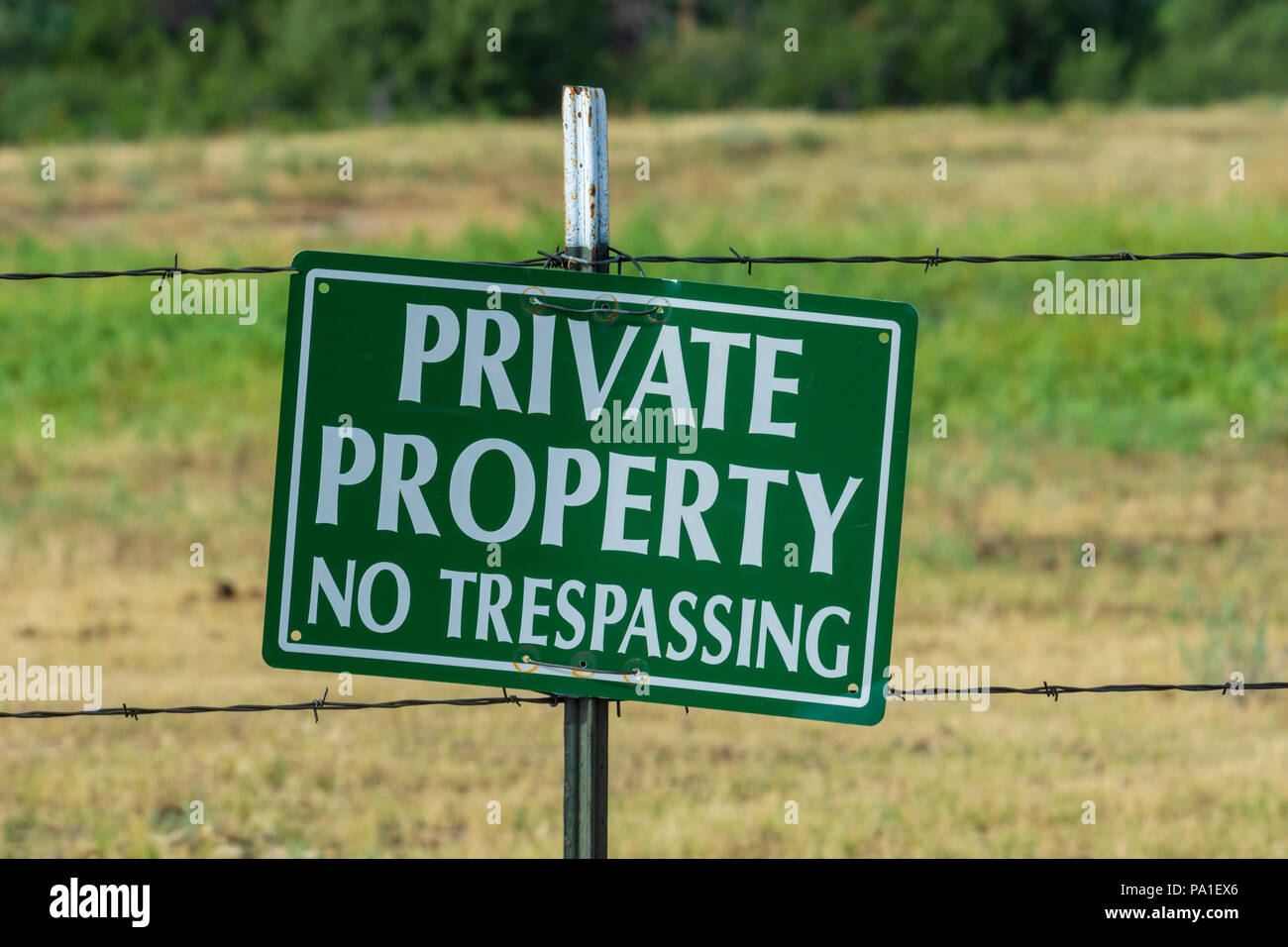Private property warning sign hanging on barb wire fence, Castle Rock