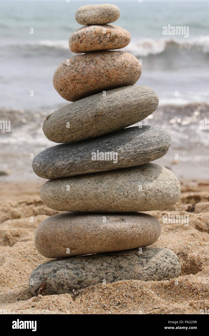 A zen-like pile of balanced smooth stones on a beach in Block Island, Rhode Island. Stock Photo
